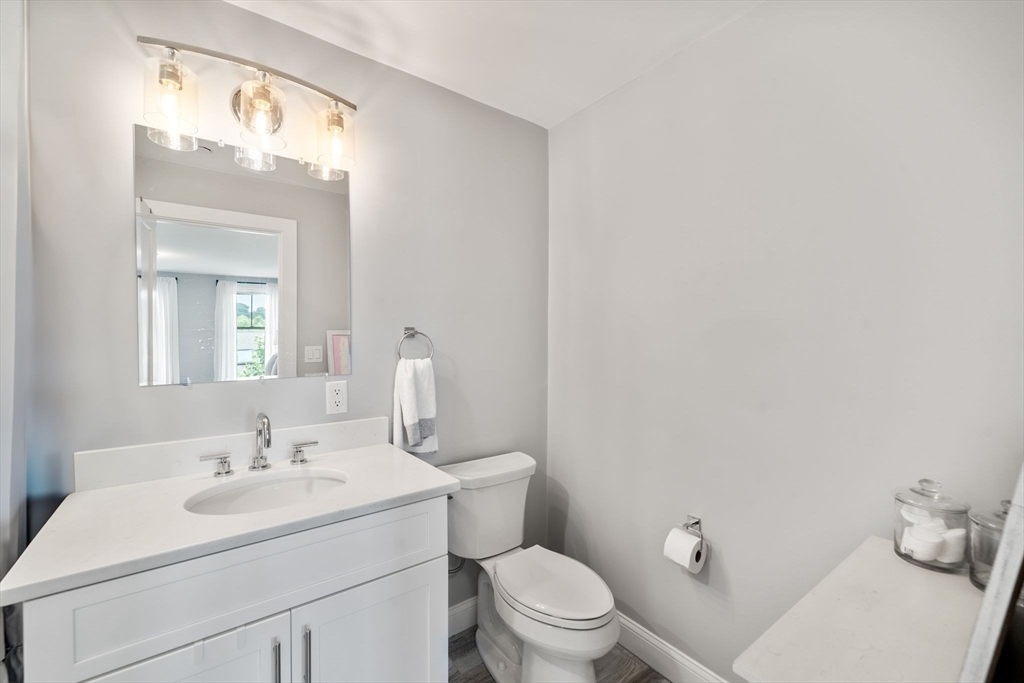 1789 Centre Street, Unit 401 Boston, MA 02132 - Photo 16 of 30 a bathroom with a sink vanity mirror and toilet