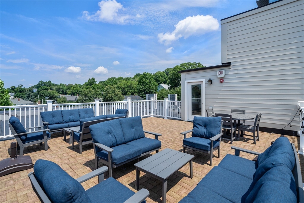 1789 Centre Street, Unit 401 Boston, MA 02132 - Photo 23 of 30 a view of a patio with couches chairs with wooden floor