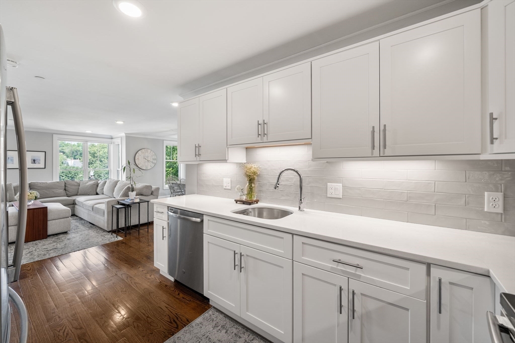 1789 Centre Street, Unit 401 Boston, MA 02132 - Photo 7 of 30 a kitchen with a sink white cabinets and white appliances