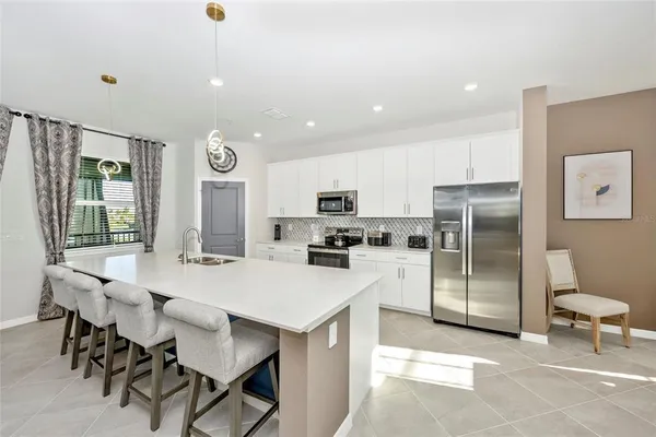 a kitchen with granite countertop a sink stove and refrigerator