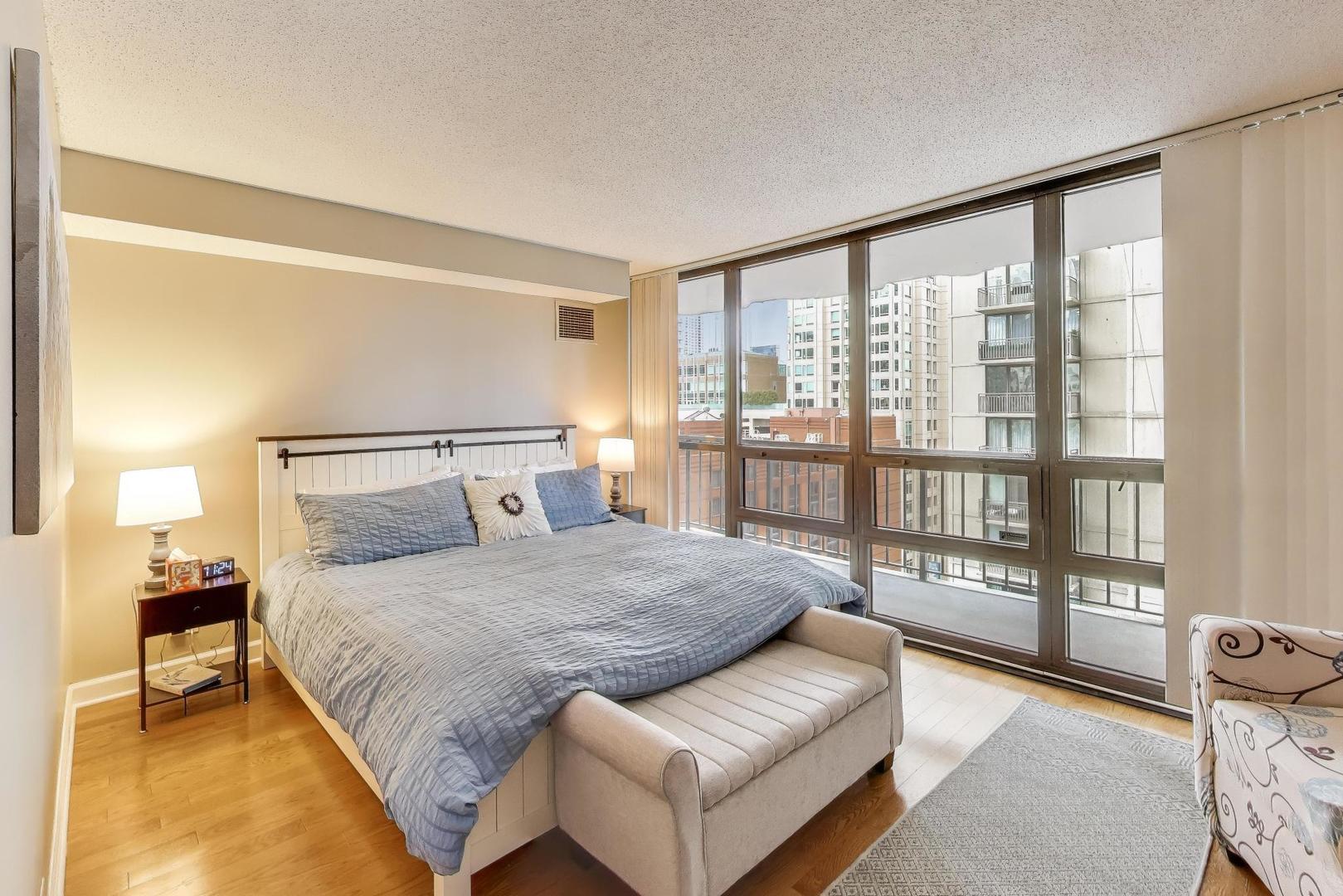 10 East Ontario Street, Unit 1205 Chicago, IL 60611 - Photo 11 of 30 a bedroom with a large bed and a large window