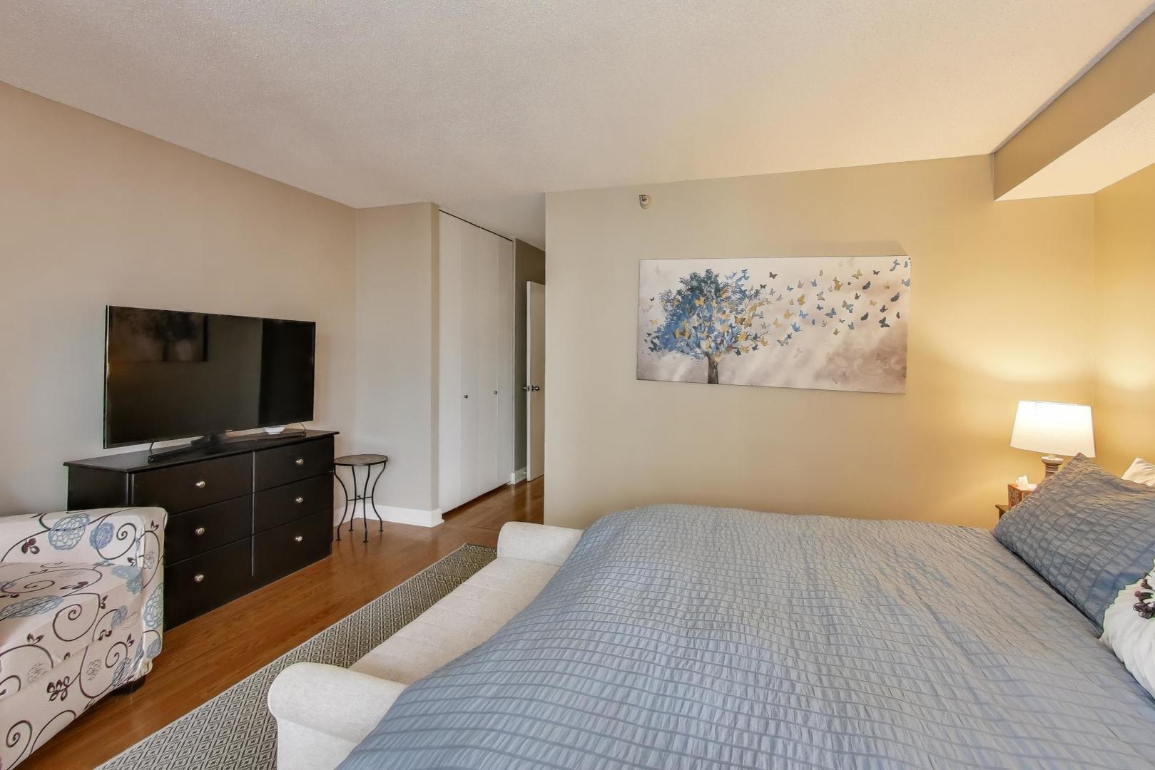 10 East Ontario Street, Unit 1205 Chicago, IL 60611 - Photo 12 of 30 a bedroom with a bed and a flat screen tv