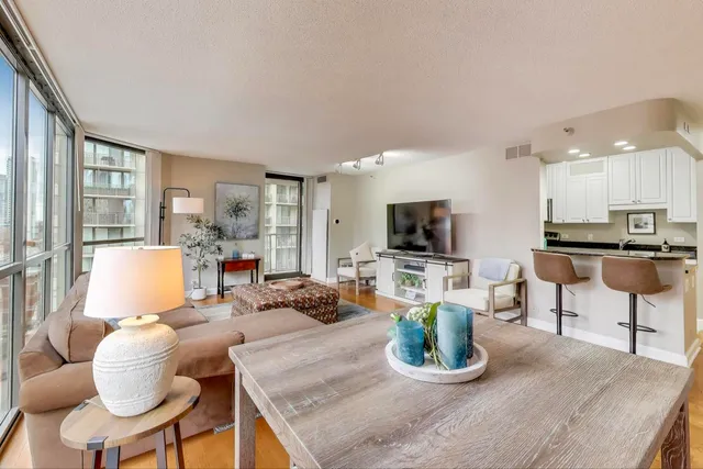 a living room with furniture a flat screen tv and a large window