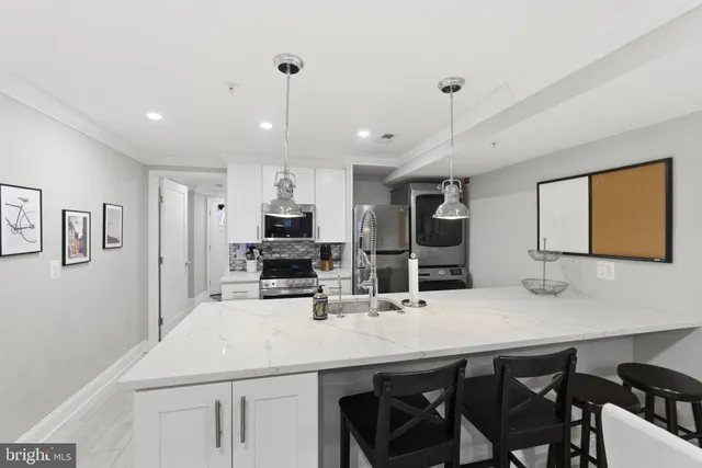 a kitchen with cabinets a sink and chairs