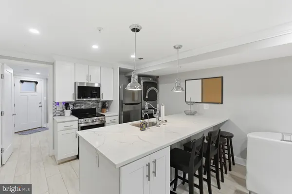 a kitchen with a dining table chairs refrigerator and microwave