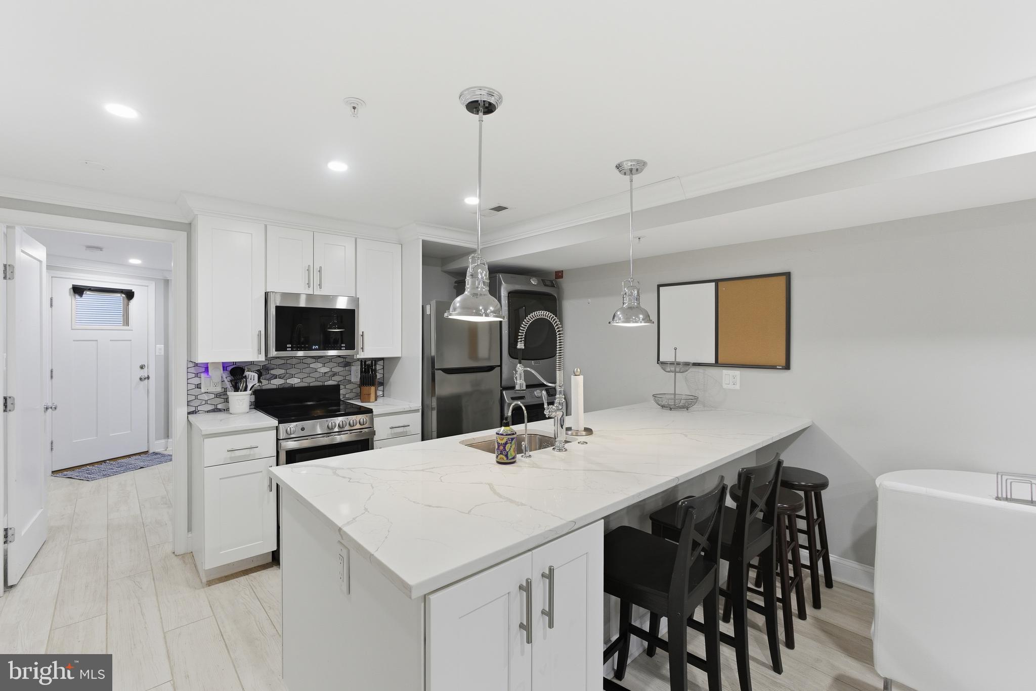 1748 S Street Northwest, Unit 2 Washington, DC 20009 - Photo 17 of 33 a kitchen with a dining table chairs refrigerator and microwave