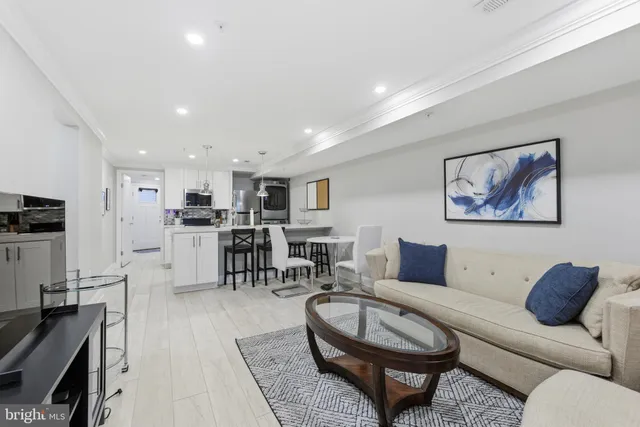 a living room with furniture a kitchen view and a dining table
