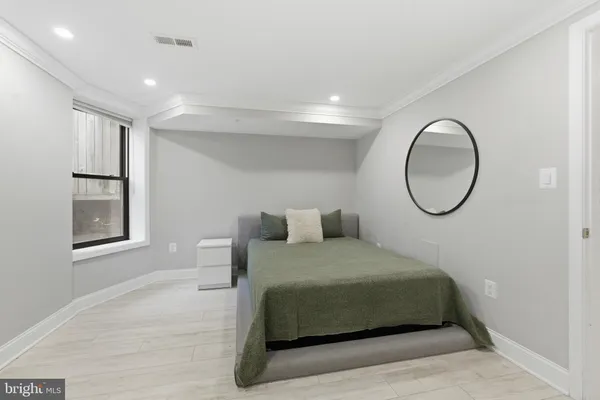 a bedroom with a bed and a painting on the wall