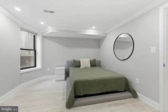 a bedroom with a bed and a painting on the wall