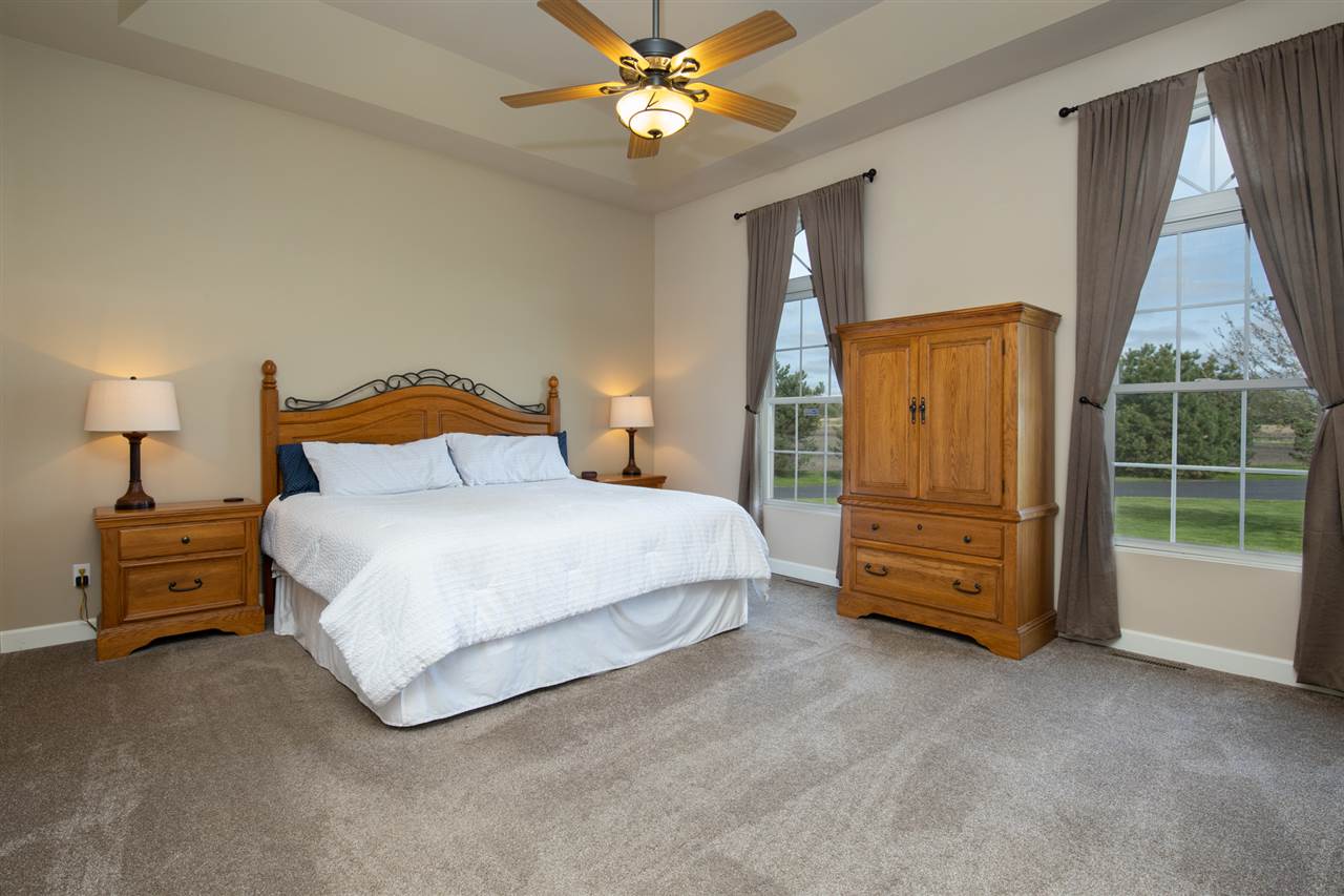 6300 Quail Trap Road Poplar Grove, IL 61065 - Photo 16 of 34 a spacious bedroom with a bed and a chandelier