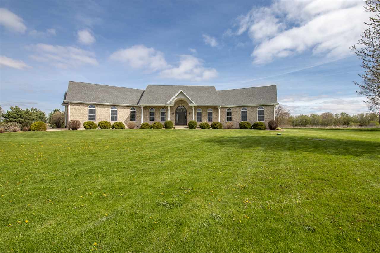 6300 Quail Trap Road Poplar Grove, IL 61065 - Photo 5 of 34 a view of a big yard next to a building with large trees