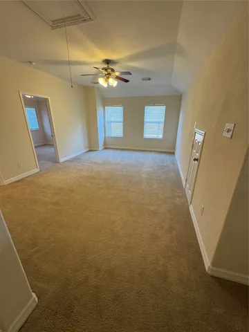 an empty room with a ceiling fan and a window
