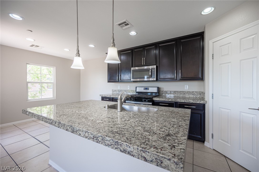 9916 Sable Point Street Las Vegas, NV 89178 - Photo 32 of 73 Culinary delights await in this modern kitchen with ample counter space and stylish pendant lighting.