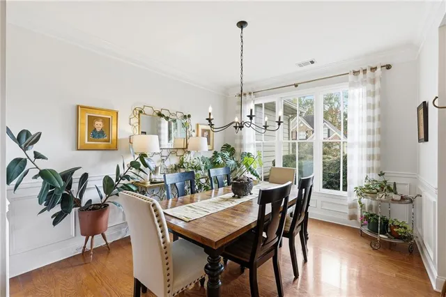 a dining room with furniture potted plants and wooden floor