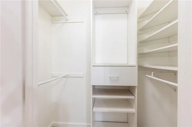 a view of walk in closet with empty racks