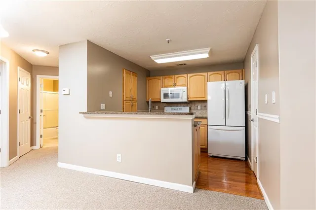 a view of a kitchen with a sink refrigerator and a window
