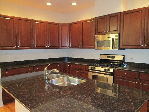 1956 Brentwood Road Northbrook, IL 60062 - Photo 7 of 16 a kitchen with wooden cabinets a stove and a microwave oven