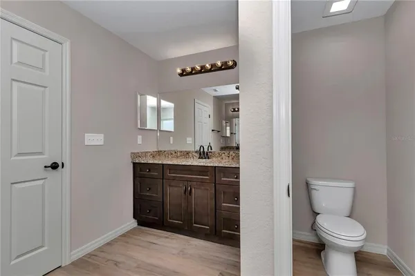 a bathroom with a toilet sink vanity and mirror