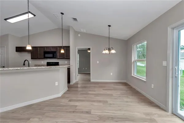 a view of a kitchen with a sink wooden floor and a window
