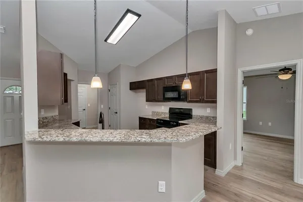 a kitchen with stainless steel appliances kitchen island granite countertop a sink and a microwave