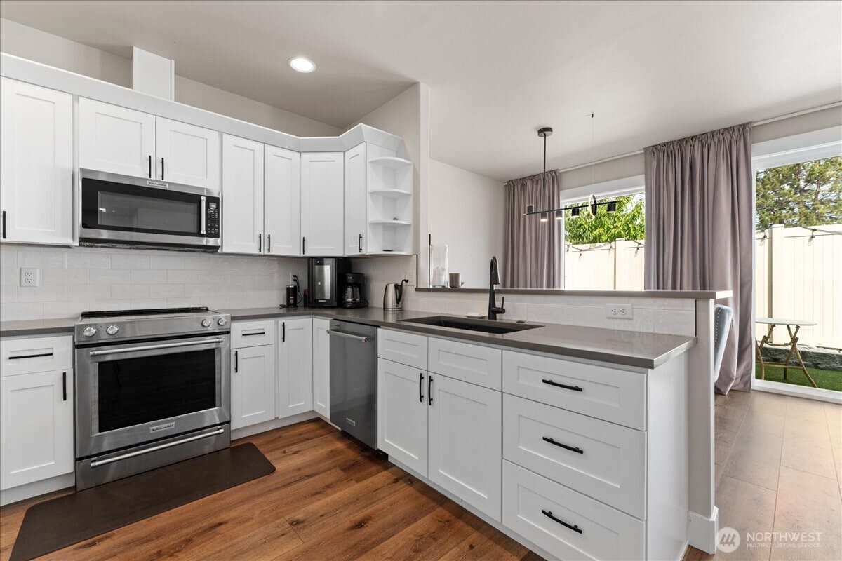 214 Solomon Loop Northwest East Wenatchee, WA 98802 - Photo 12 of 38 a kitchen with stainless steel appliances granite countertop a stove a sink and a microwave
