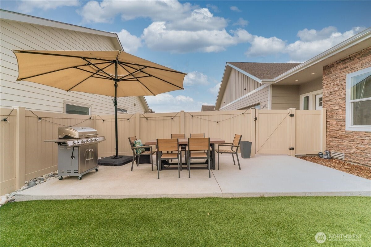 214 Solomon Loop Northwest East Wenatchee, WA 98802 - Photo 27 of 38 a view of a backyard with table and chairs under an umbrella
