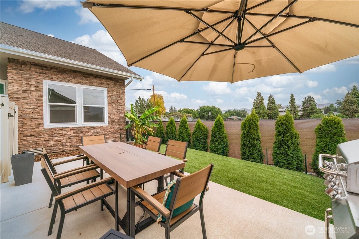 214 Solomon Loop Northwest East Wenatchee, WA 98802 - Photo 29 of 38 a view of a patio with table and chairs under an umbrella