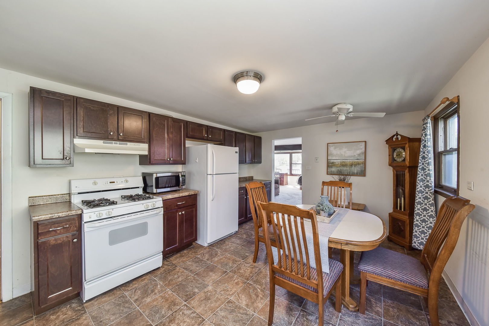 684 Robertson Road South Elgin, IL 60177 - Photo 3 of 18 a kitchen with a dining table chairs and refrigerator