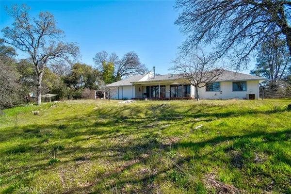 a view of house with yard and outdoor seating