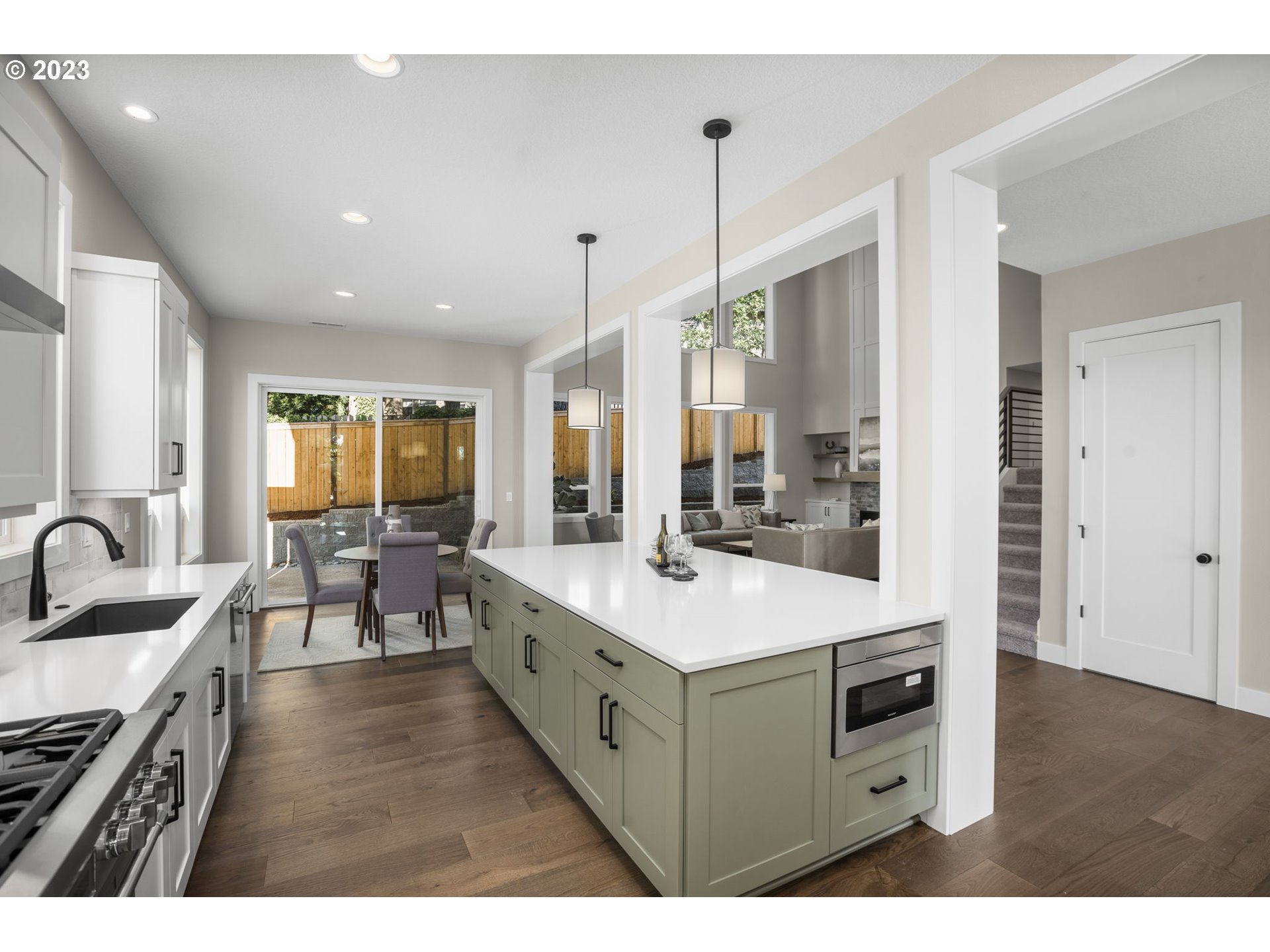 8878 Southwest Lintner Terrace Portland, OR 97223 - Photo 12 of 42 a large white kitchen with a stove a sink a dining table and chairs