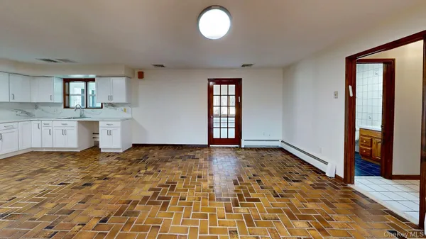 a open kitchen with white cabinets and wooden floor