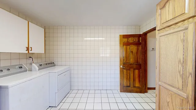 a utility room with cabinets dryer and washer