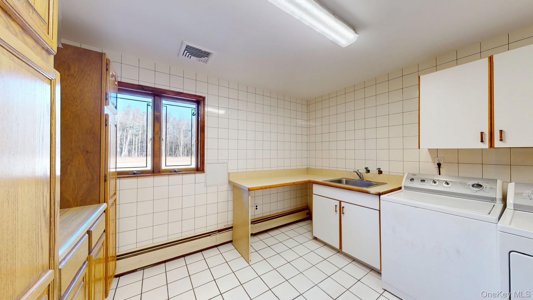 565 Prosperous Valley Road Middletown, NY 10940 - Photo 26 of 47 a utility room with cabinets dryer and washer