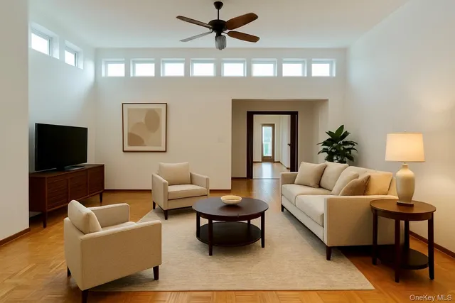 an empty room with chandelier fan and windows