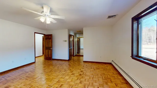 a view of empty room with wooden floor