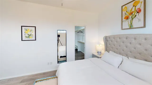 a bedroom with a bed and painting on the wall