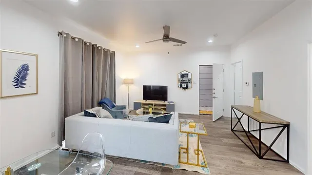 a living room with furniture a flat screen tv and a table