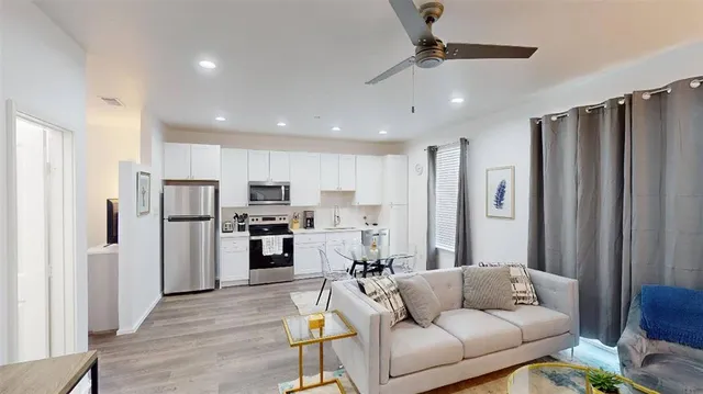 a living room with stainless steel appliances furniture and a view kitchen