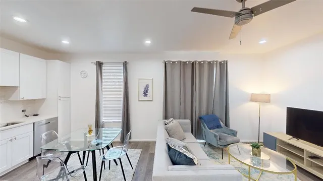 a living room with furniture a flat screen tv and a view of kitchen