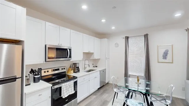 a kitchen with stainless steel appliances a stove a sink a microwave and cabinets