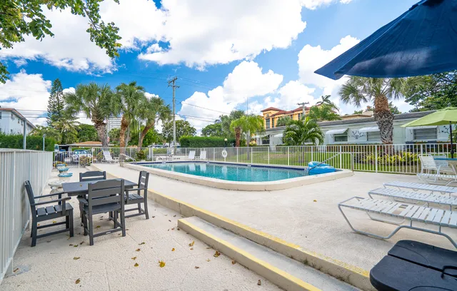 a view of a patio with a table and chairs under an umbrella
