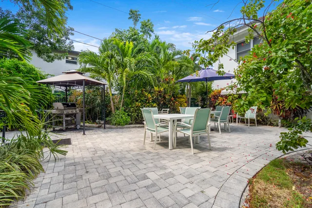 a view of a patio with table and chairs under an umbrella