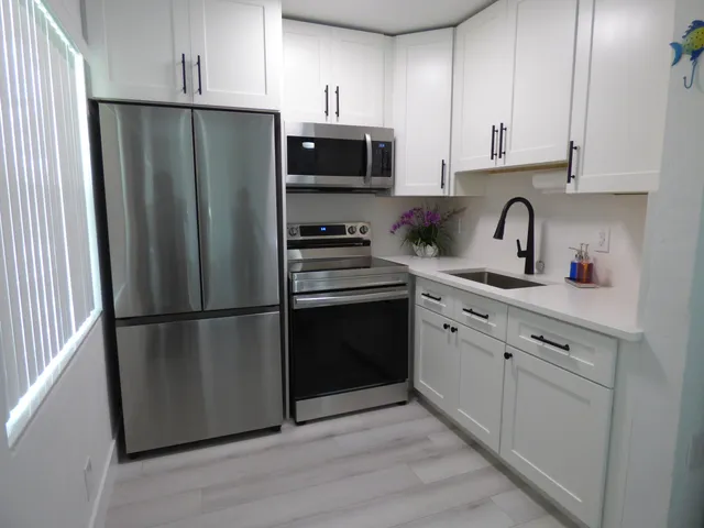 a kitchen with a refrigerator stove and white cabinets