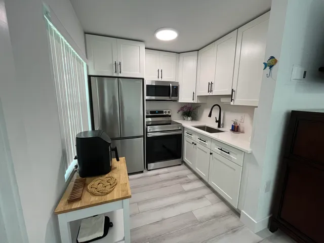 a kitchen with a refrigerator and a stove top oven