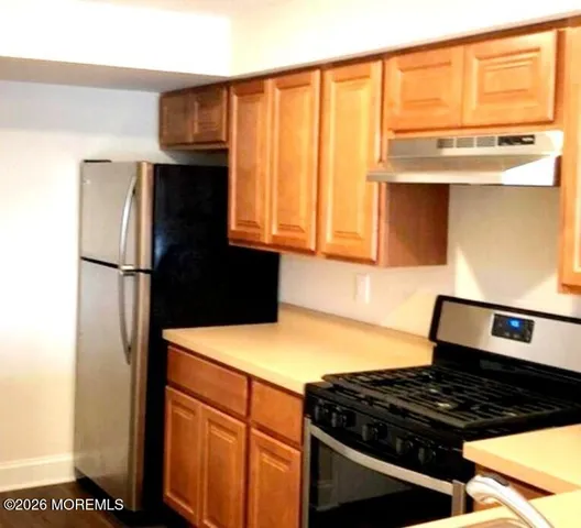 a kitchen with stainless steel appliances granite countertop a refrigerator and a stove