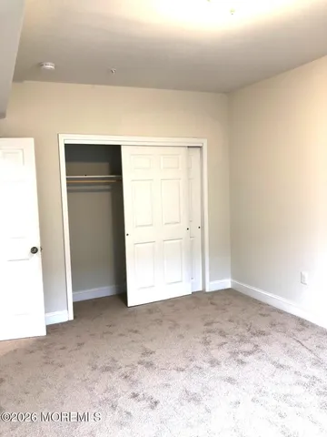 a view of an empty room and kitchen