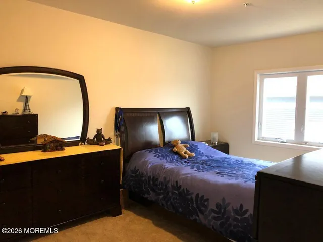 a bedroom with a bed and dresser with mirror
