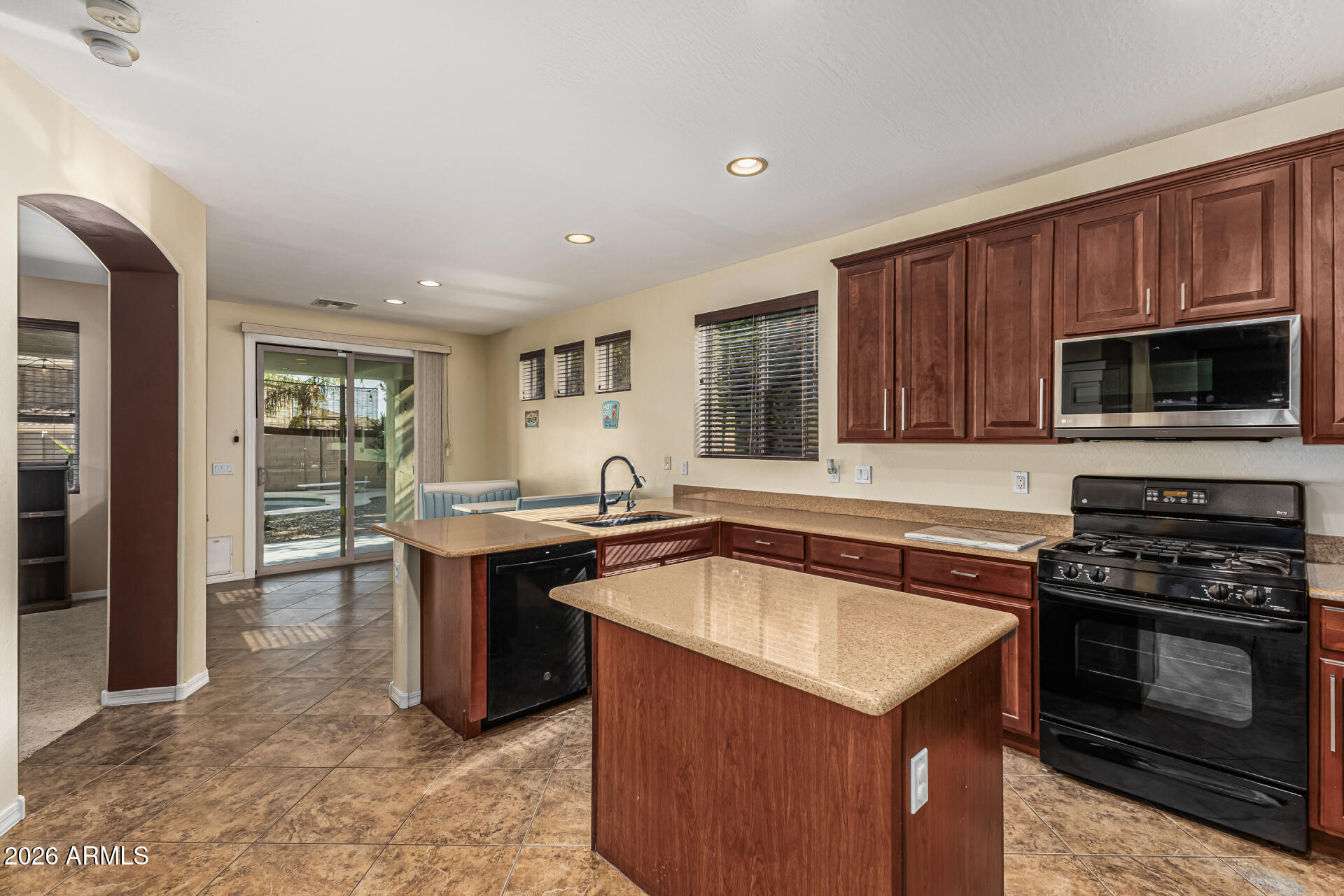 5513 West Rowel Road Phoenix, AZ 85083 - Photo 13 of 55 a kitchen with stainless steel appliances granite countertop a stove a sink and a microwave
