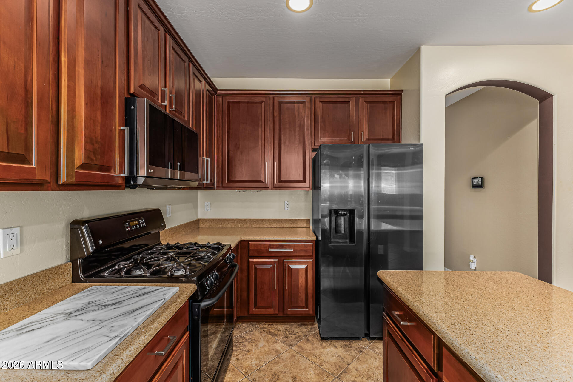 5513 West Rowel Road Phoenix, AZ 85083 - Photo 16 of 55 a kitchen with stainless steel appliances granite countertop a stove refrigerator and microwave