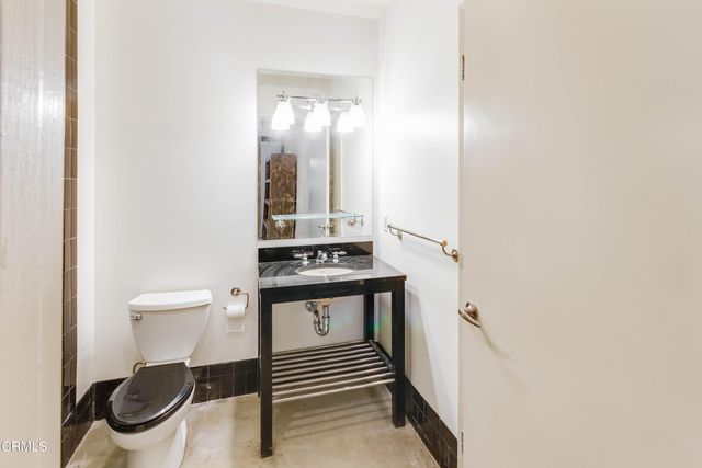 a bathroom with a toilet a sink and mirror